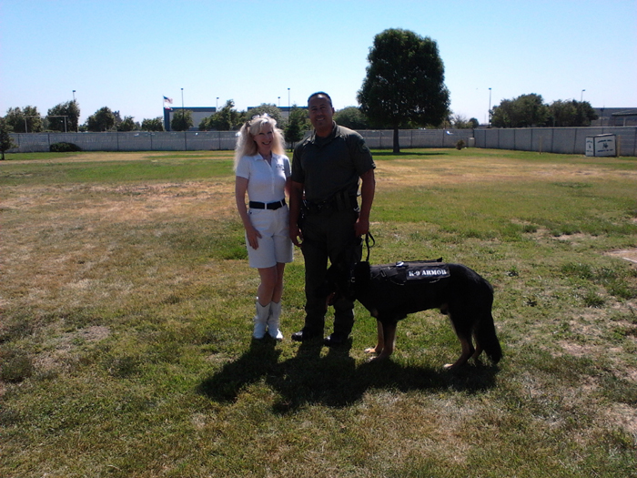 Stanislaus County Sheriff K9 Max tries on a bulletproof K9 Armor vest, with Suzanne Saunders and Deputy Hinostroza.