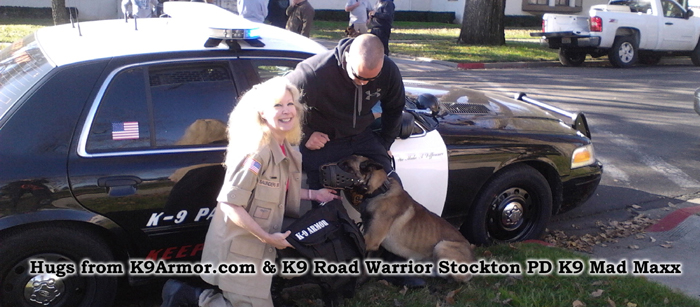 K9 Armor Co-founder Suzanne Saunders shakes paws with Road Warrior Stockton PD K9 Mad Maxx